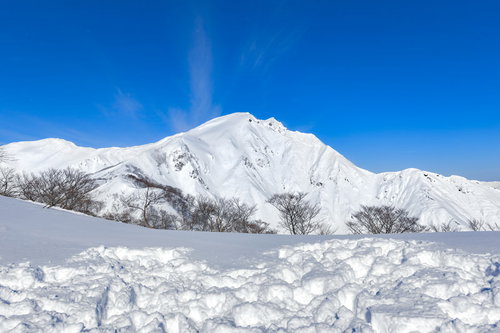 青空の元で真っ白に雪化粧した谷川岳の雪山風景