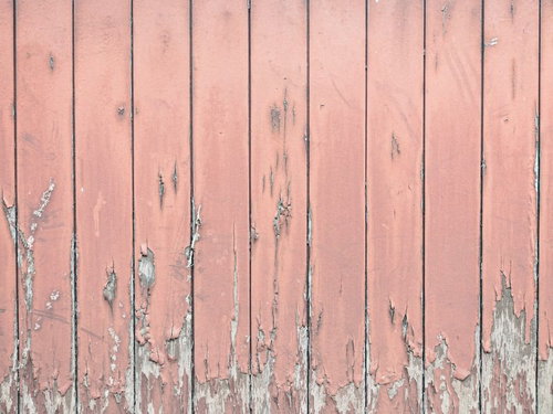塗装が剥げたピンク色の木目板の縦板壁、老朽化したテクスチャー