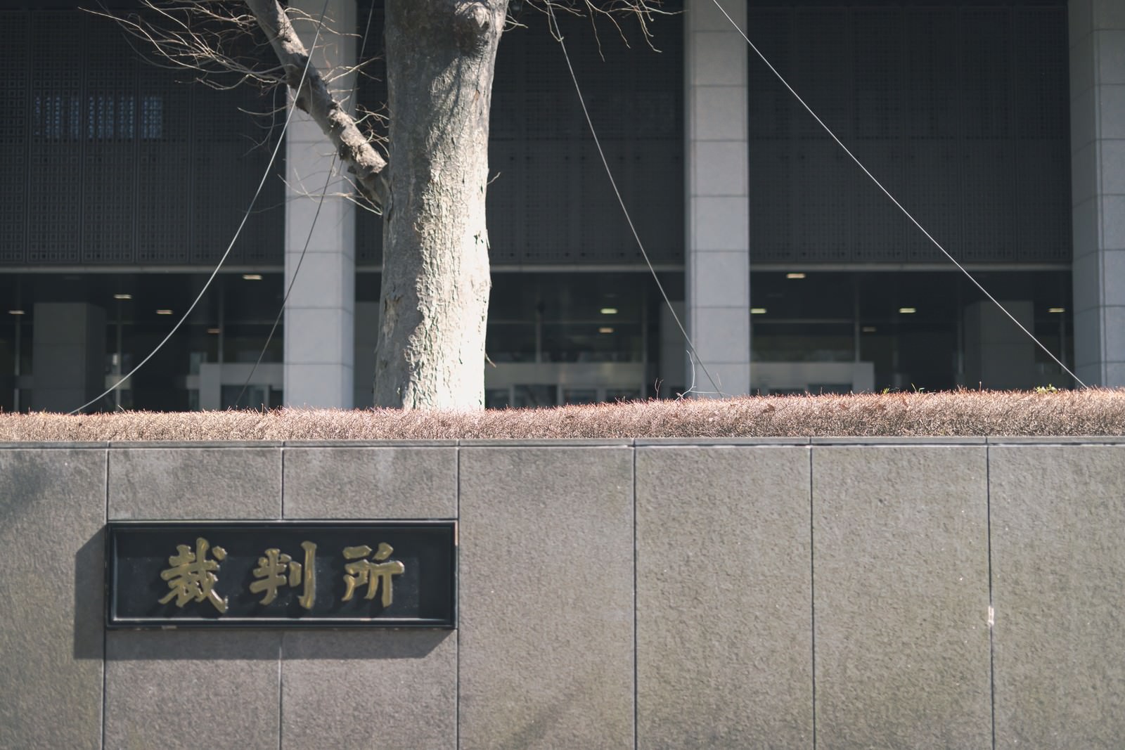 コンクリートの塀に設置された黒い裁判所の銘板