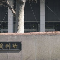 コンクリート塀に設置された裁判所の銘板と建物の写真