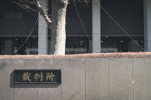 コンクリート塀に設置された裁判所の銘板と建物