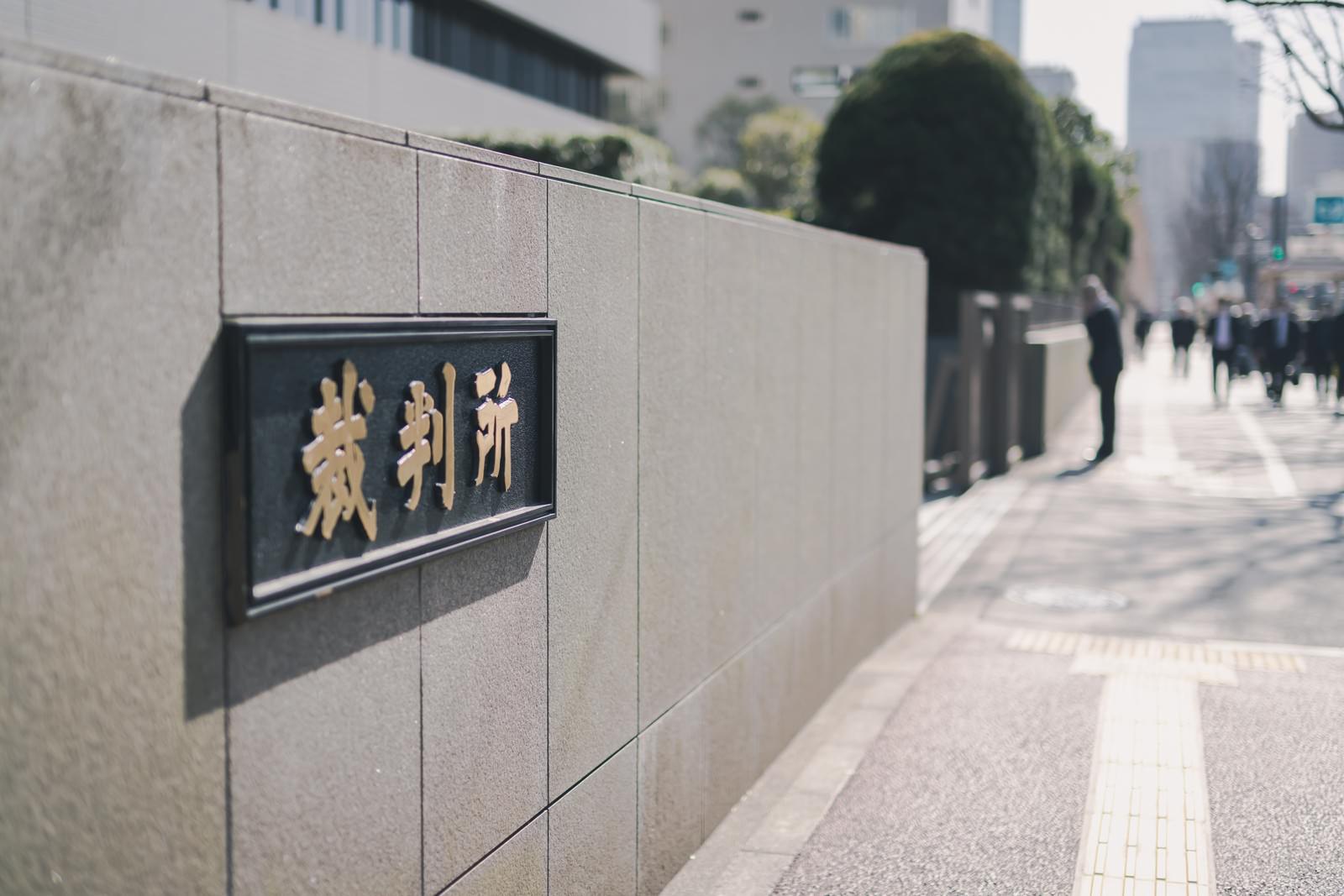 石材の壁に設置された黒い裁判所の銘板