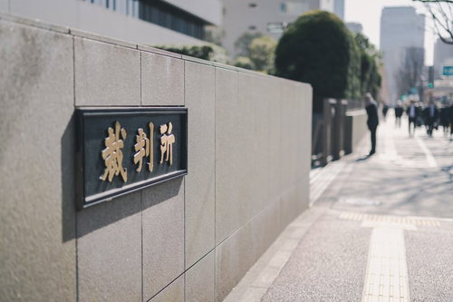 裁判所前の銘板と歩道 石材壁面の黒い看板と街並み