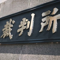 石材に彫刻された裁判所の銘板と建物外壁の写真