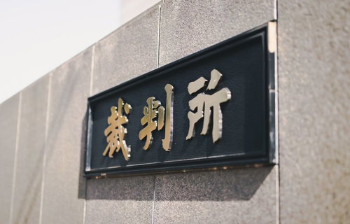 裁判所銘板と影が映る壁面