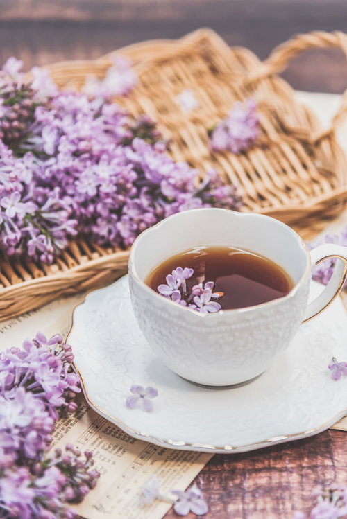 ライラックの花びら浮かぶティーカップの紅茶