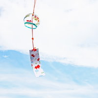 青空に揺れる風鈴の音色：夏の涼感を表現する和風の写真