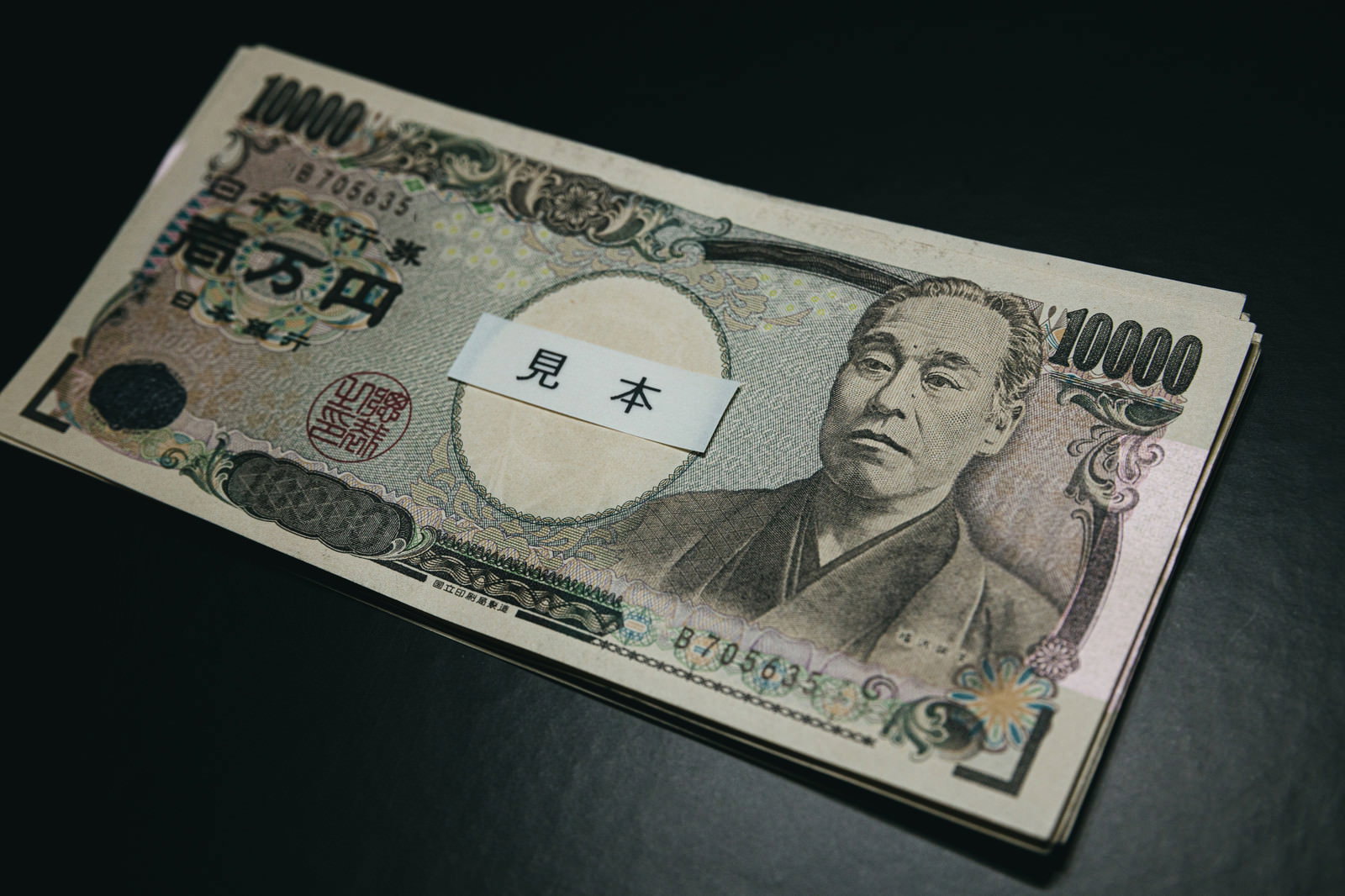 見本スタンプが押された壱万円札10枚が重ねて置かれている