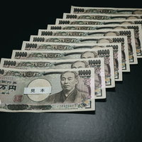 10万円の給付金を一万円札で並べた黒い背景での配置の写真