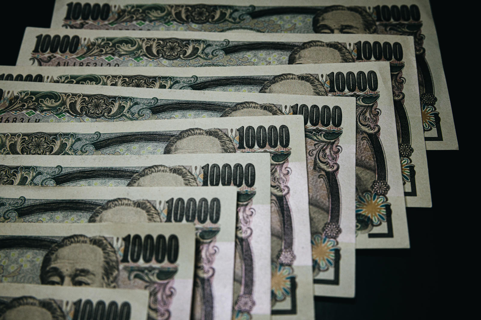 テーブルの上に重ねて並べられた複数枚の1万円札