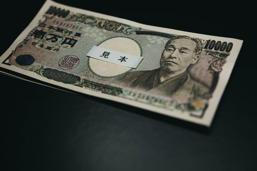 暗い背景に並べた壱万円札10枚の現金