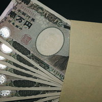 封筒から溢れ出す数枚の壱万円札の写真