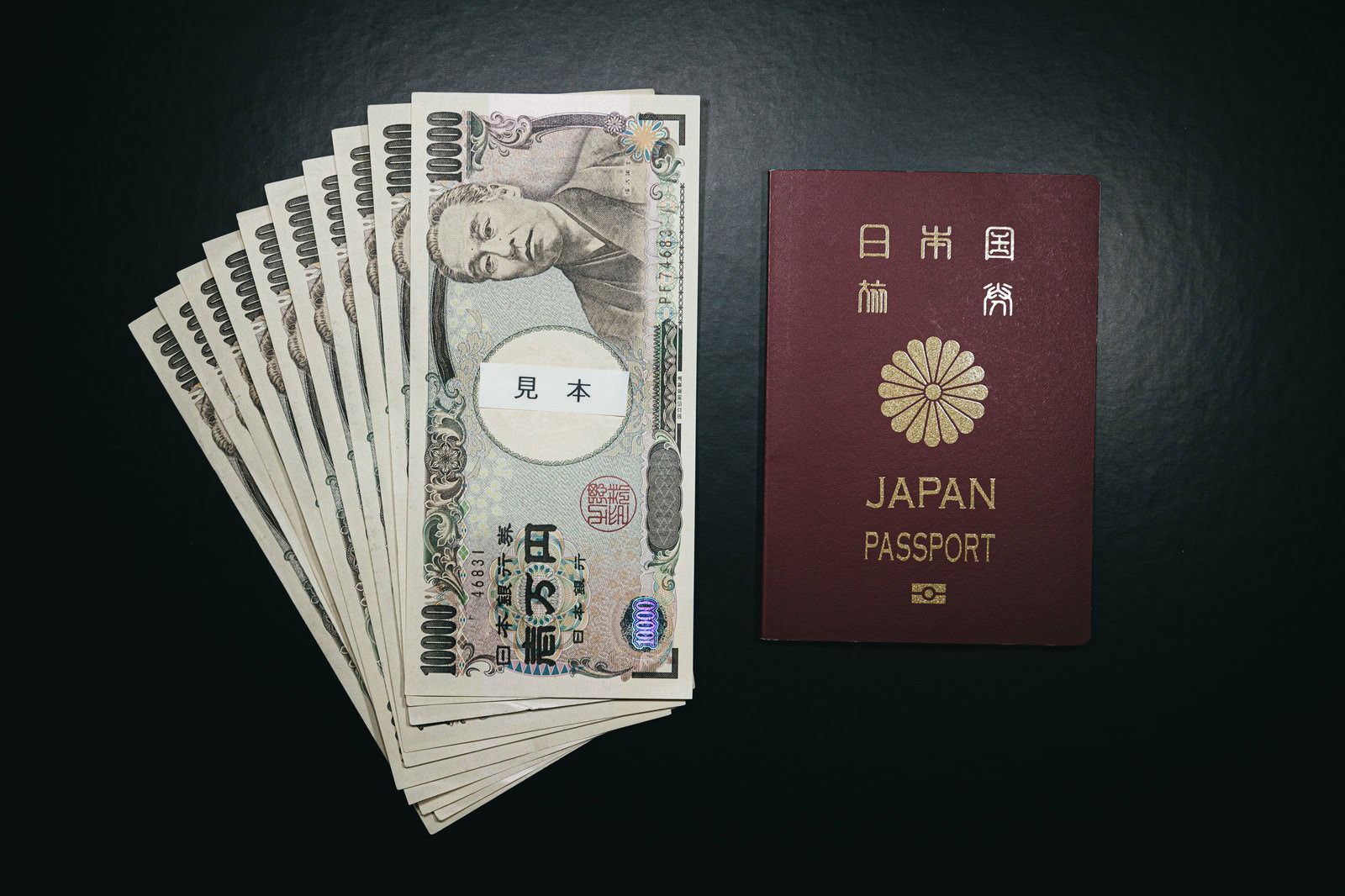 複数枚の一万円札と日本のパスポートが並んで配置された写真