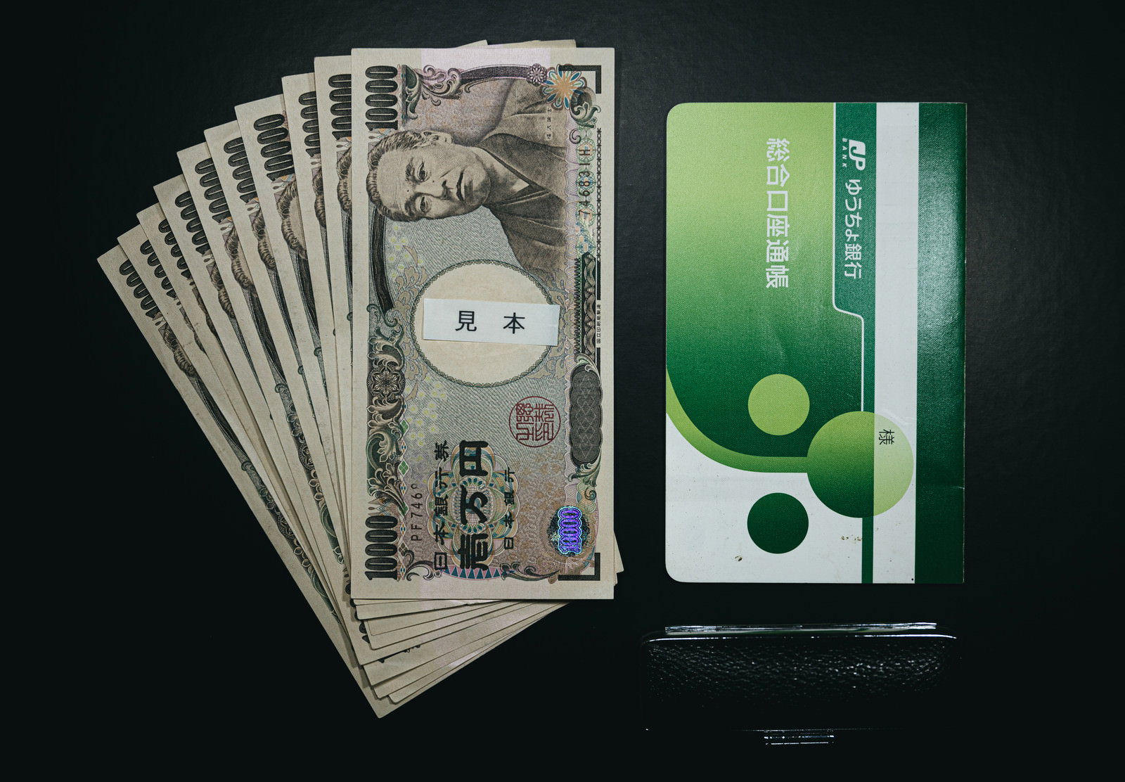 10万円分の一万円札と銀行通帳、印鑑が並べて置かれている