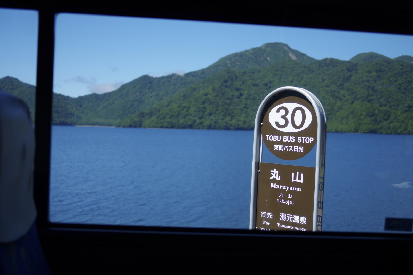 バスの車窓から見た日光白根山の風景、手前に制限速度30キロの標識