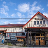 北海道・川湯温泉駅の赤い屋根の木造駅舎と駅前風景の写真