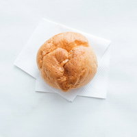 テイクアウトしたシュークリームをフォークで食べるの写真