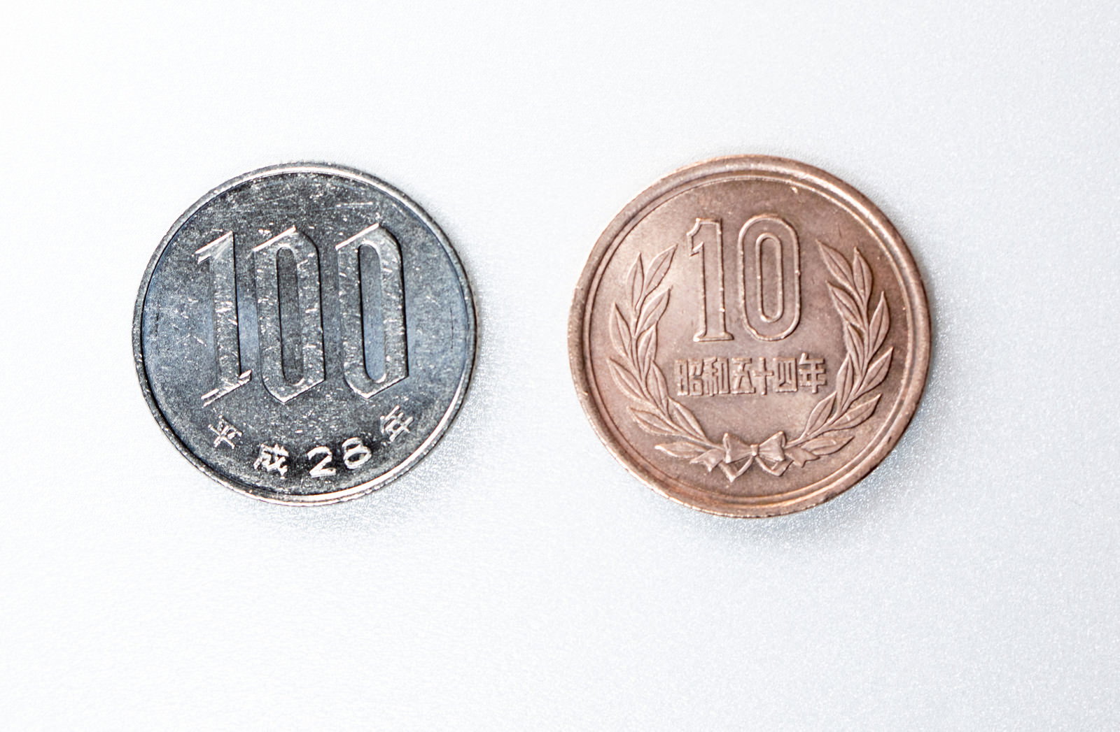 白い背景に100円玉と10円玉が並んで置かれている
