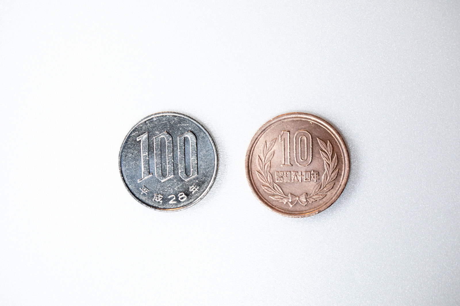 白い背景に並んだ100円玉と10円玉の硬貨