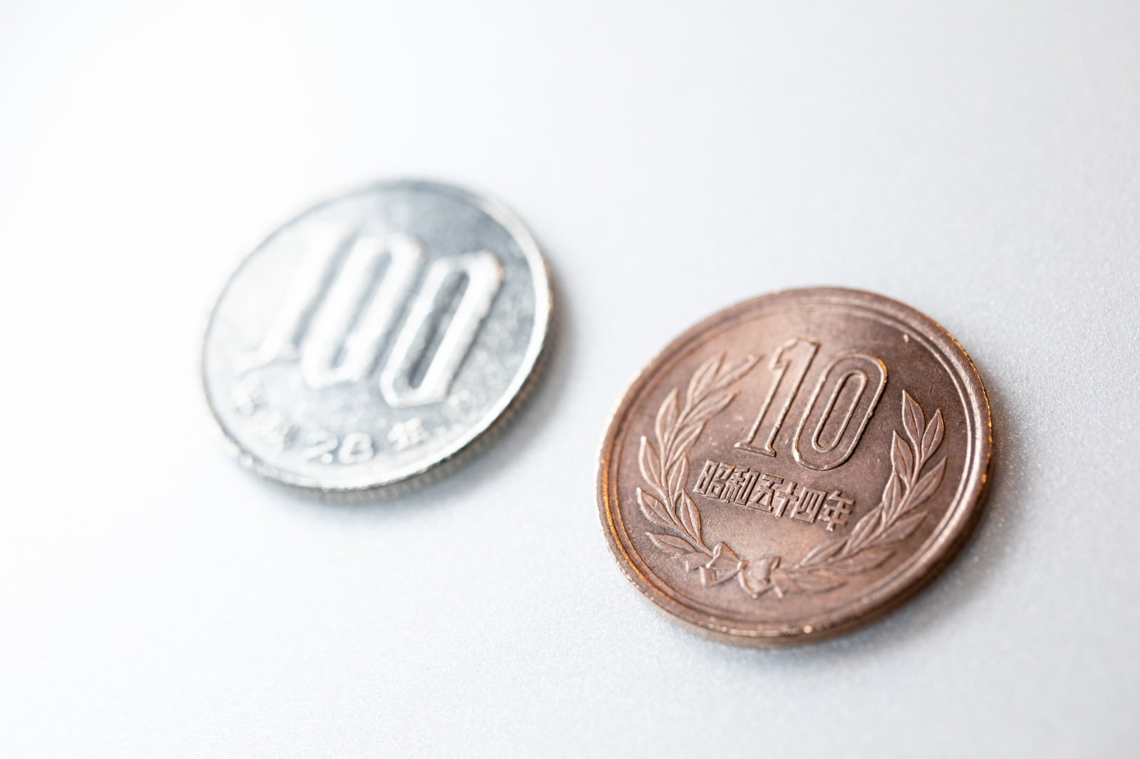 白い背景に置かれた100円玉と10円玉の硬貨