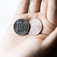 お会計税込み10％で110円です。手のひらの100円硬貨と1円硬貨の写真