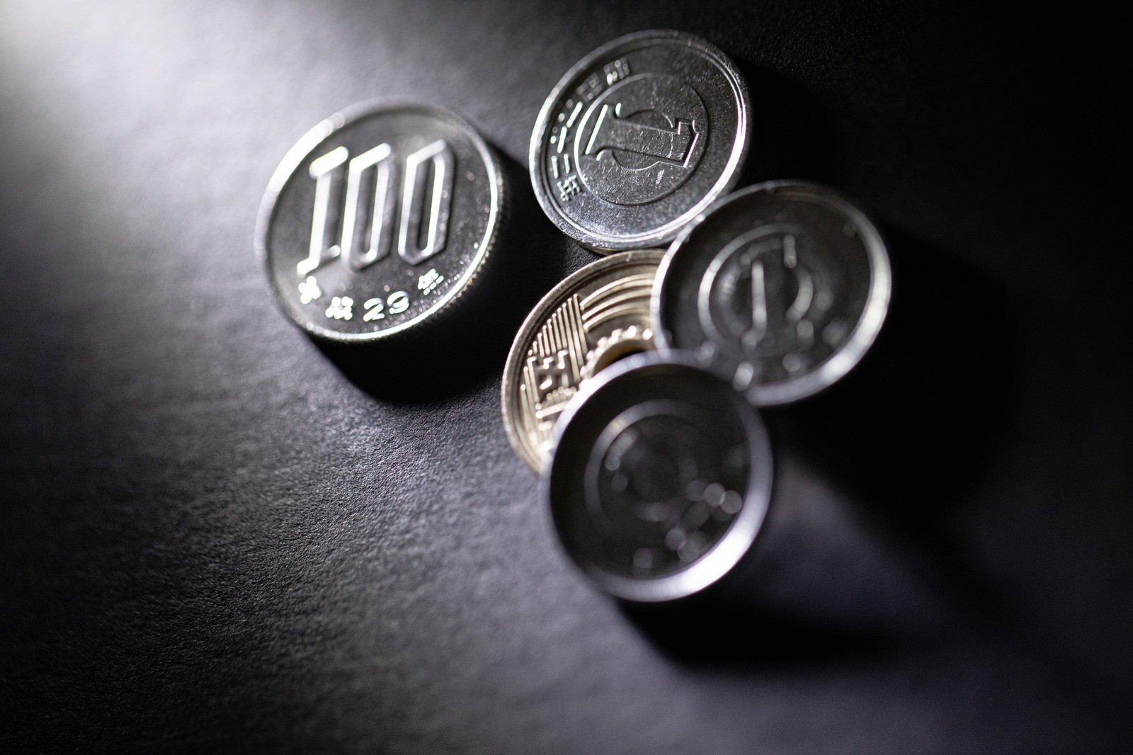 テーブルの上に置かれた100円硬貨と1円硬貨4枚