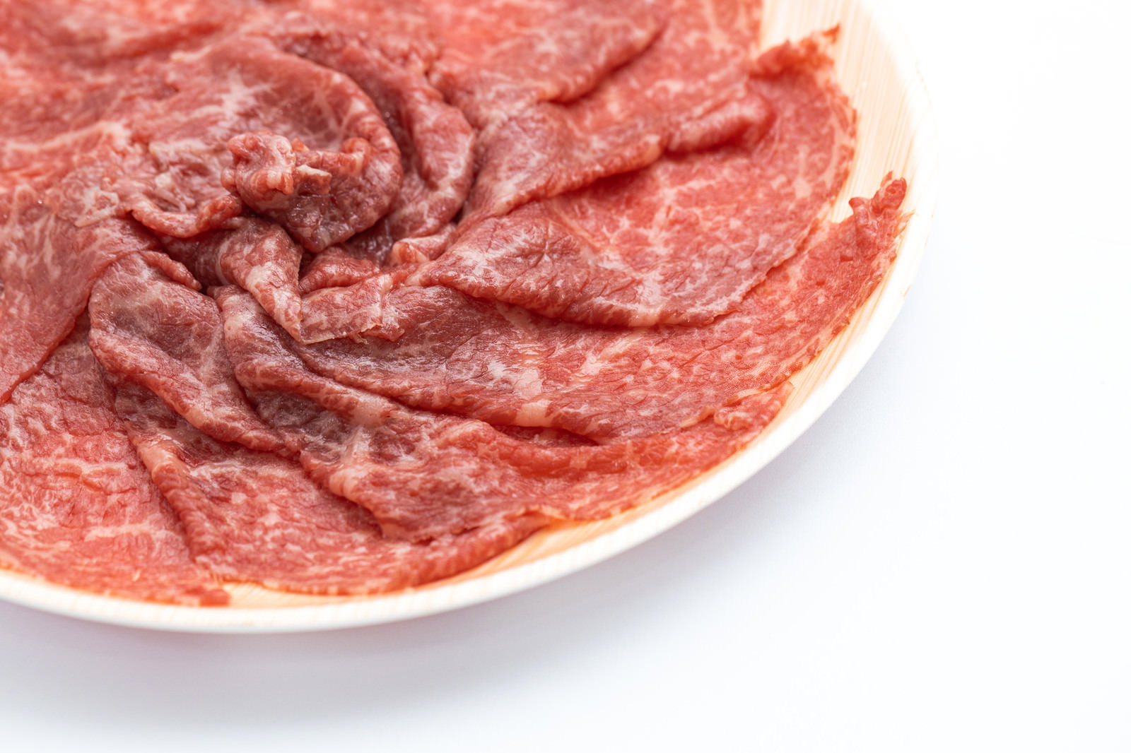 白い皿に並べたしゃぶしゃぶ用霜降り牛肉