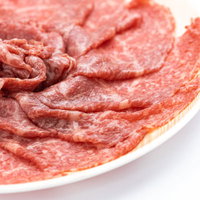 白い皿に盛ったロース肉バラ盛り、しゃぶしゃぶ用薄切り牛肉の写真