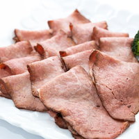 白い皿に盛り付けたローストビーフともも肉のステーキの写真