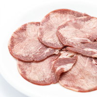 白い皿に盛り付けた一人前のタン塩、薄くスライスされた牛タンの写真