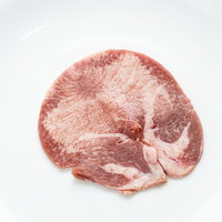白い皿に盛られた新鮮な牛タン、焼肉用高級食材の写真