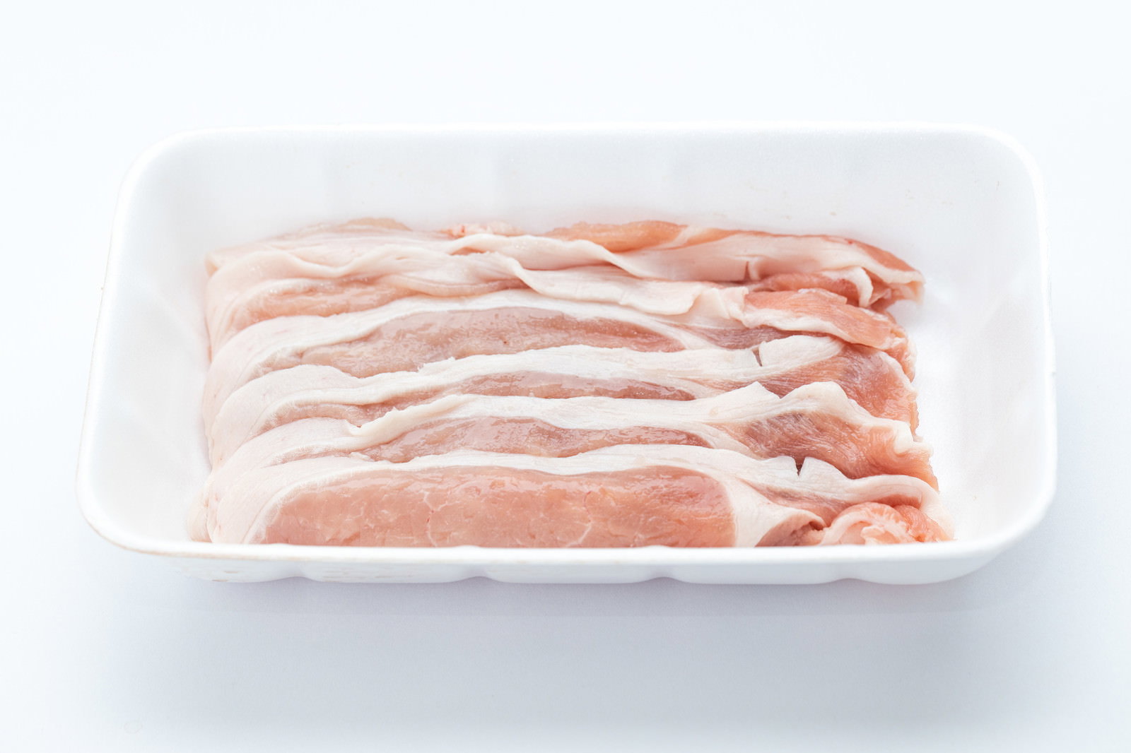 白いトレーに整然と並べられた薄切りの豚ロース肉