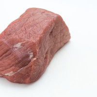 白い背景に置かれた牛のモモ肉ブロックの写真の写真