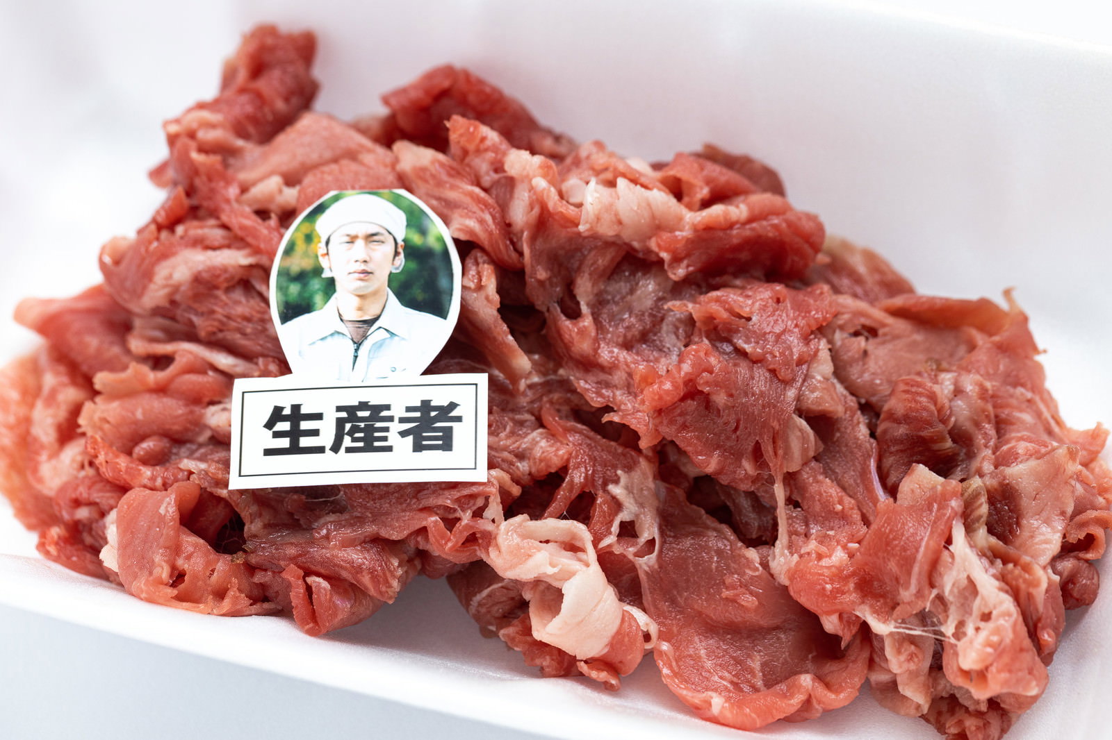 白い食品トレーに盛り付けられた生産者ラベル付きの牛肉細切れ［モデル：大川竜弥］