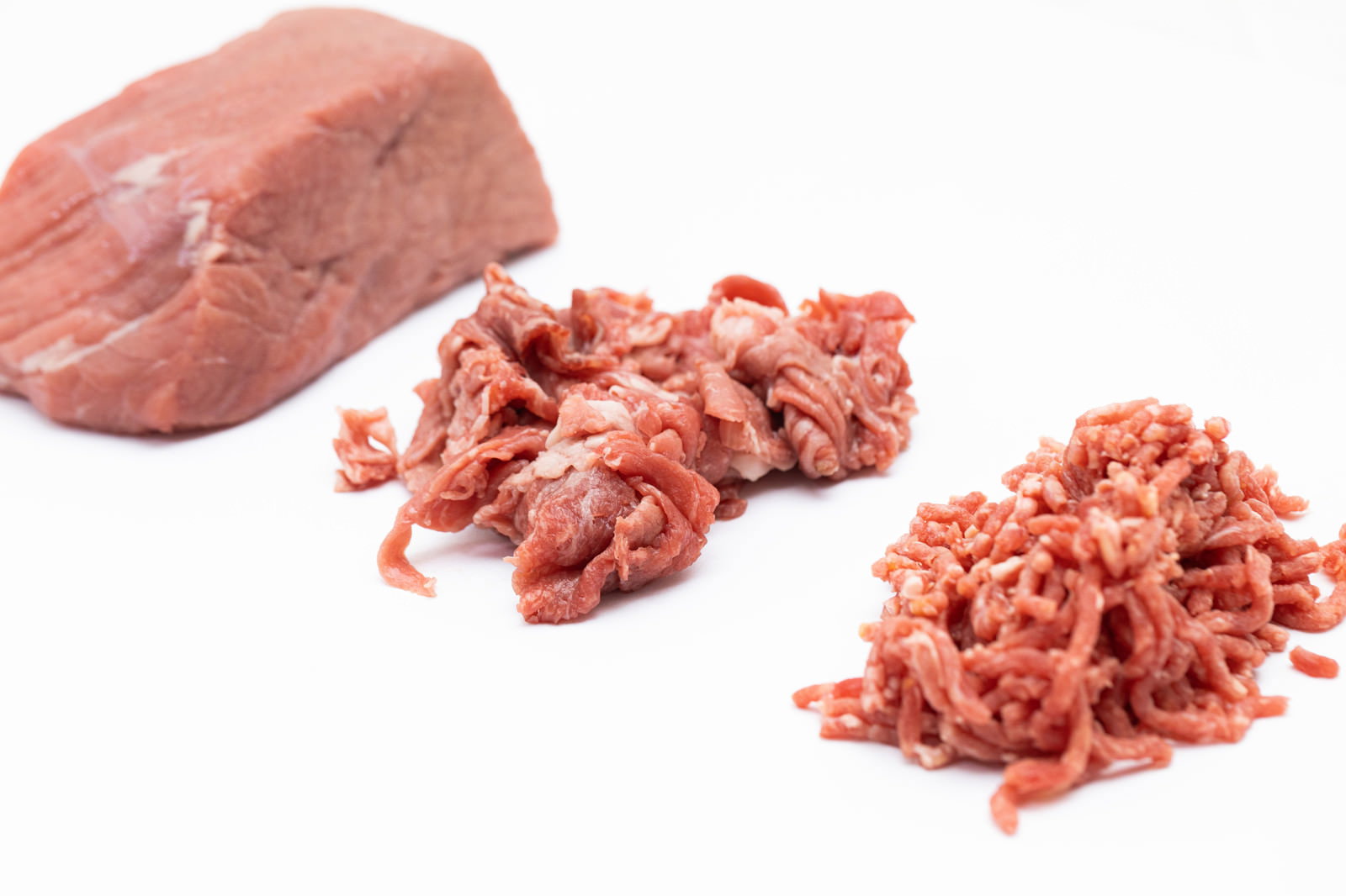 ブロック肉から細切れ、ミンチへと段階的に加工された牛肉