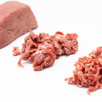 ブロック肉から細切れ、ミンチへと段階的に加工される牛肉の写真