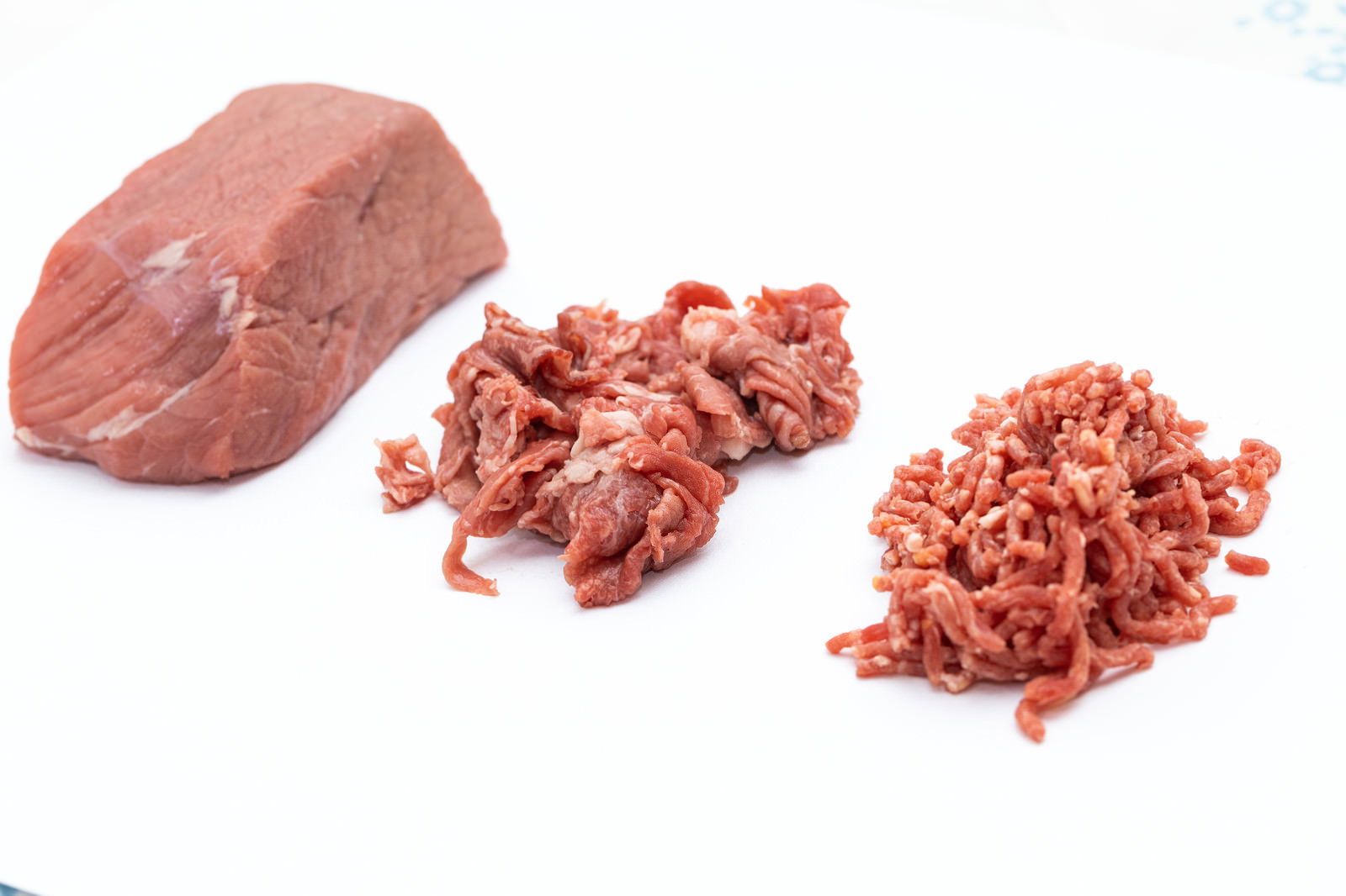白い背景に並んだブロック肉と細切れ肉と挽肉