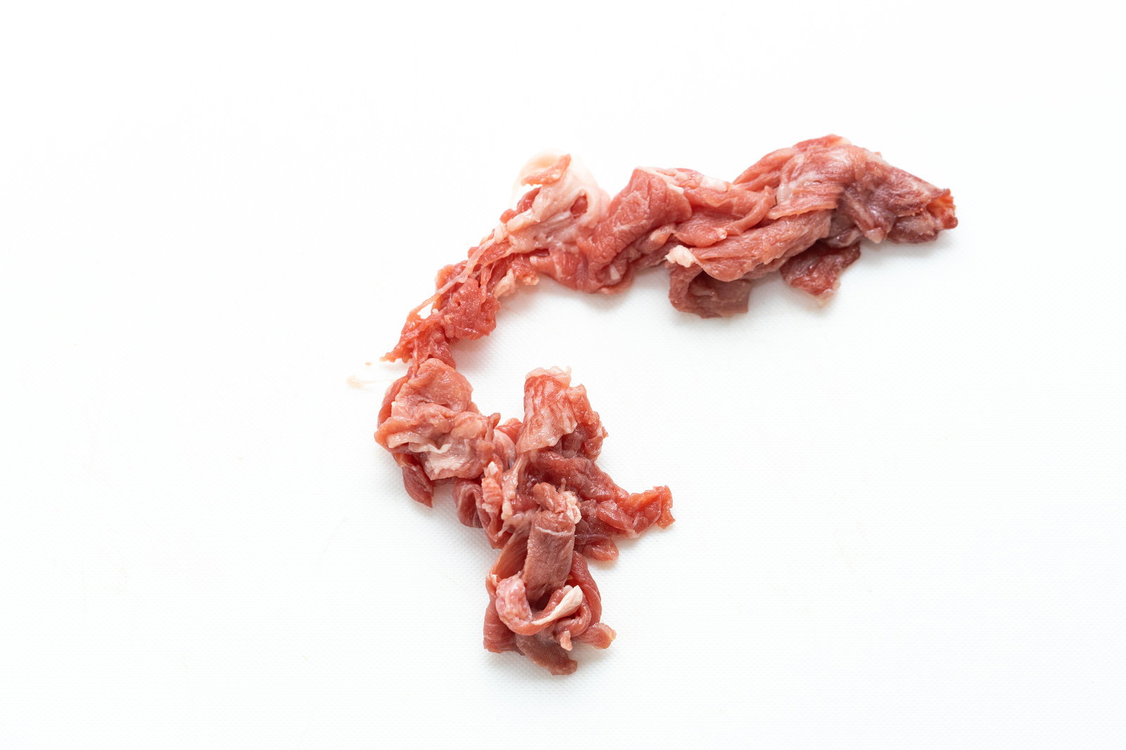 白い背景に散らばった細切れ牛肉