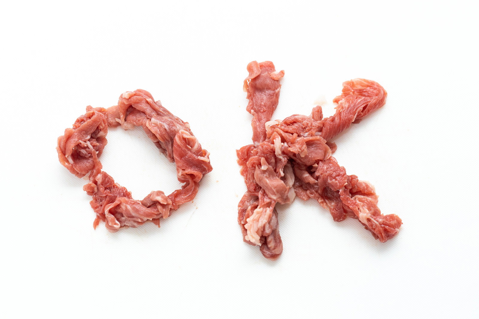 白い背景に牛肉の細切れ肉でOKの文字を作った写真