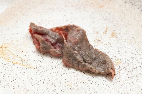まだ完全に火がとおっていない焼肉の牛肉をグリルで焼いた状態