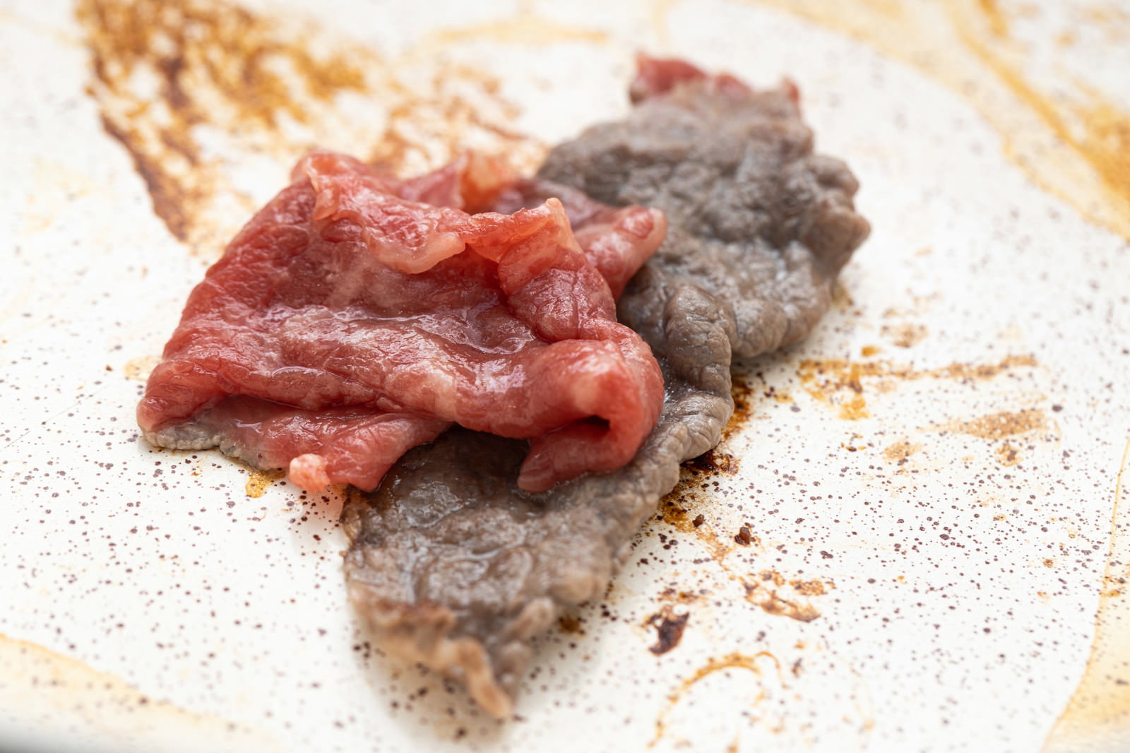 木製のまな板の上に置かれた生焼けの牛肉