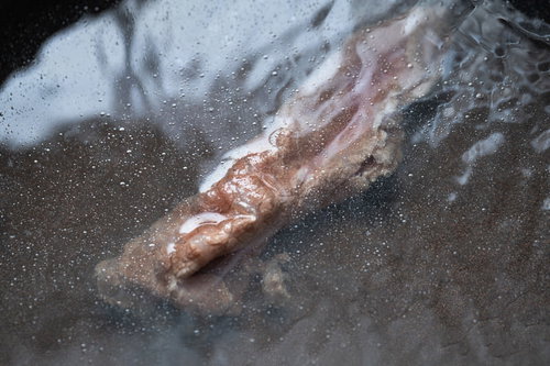 しゃぶしゃぶで茹でられている牛肉と灰汁が浮き上がる様子