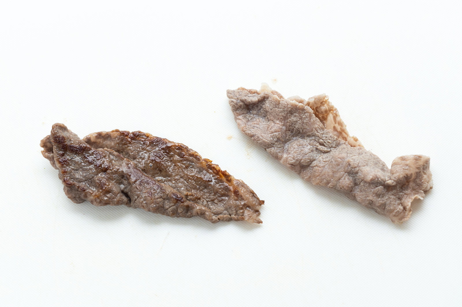 白背景に置かれた焼いた牛肉と茹でた牛肉