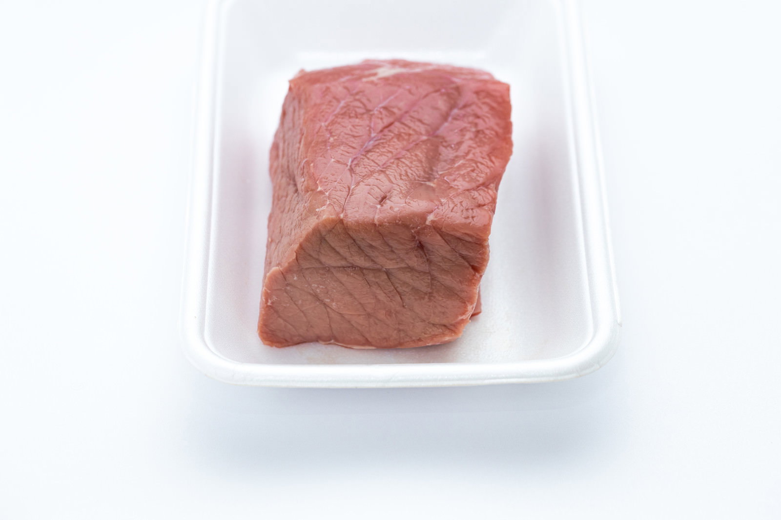 白いトレーに入った赤身のモモ肉のブロック