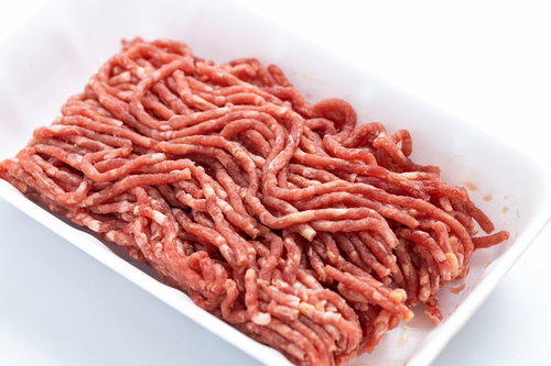 白い食品トレーに斜め向きにアップされた合挽肉