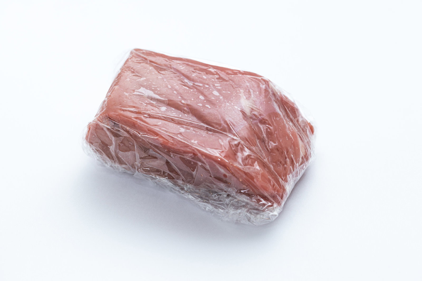 透明なラップに包まれた赤身の牛肉塊