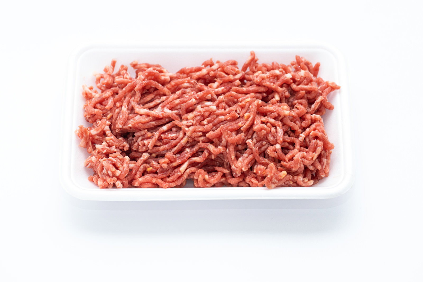 白いトレーに盛られた赤みがかった新鮮な牛豚合挽肉