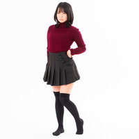 腰に手を当てて決めポーズする赤いトップスの女性の写真