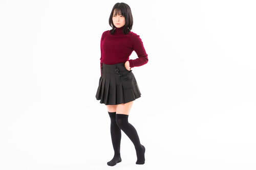 腰に手を当てて決めポーズする赤いトップスの女性