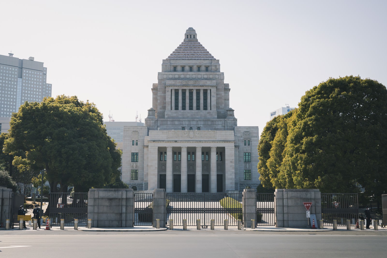 曇り空の下に立つ白い国会議事堂の建物